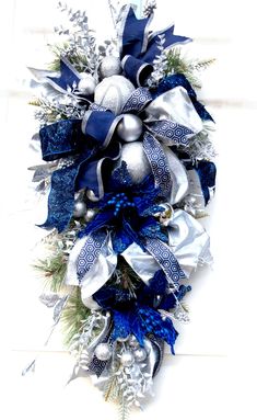 a blue and silver christmas wreath hanging on the wall