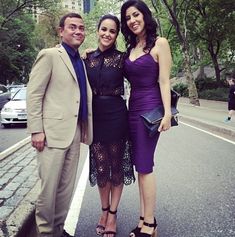 two women and a man are standing on the street