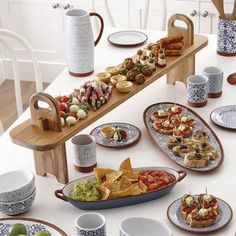 a table filled with plates and bowls full of different types of food, including tortillas