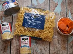 the ingredients to make an egg noodle soup laid out on top of a wooden table