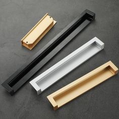 three different types of drawer pulls on a black surface with gold and white trims