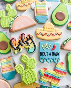 decorated cookies are arranged on a plate with the word baby spelled in cursive