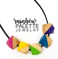 the rainbow palette jewelry necklace is made with colored wooden beads and black cord, on a white background