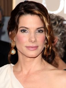 an image of a woman with her hair pulled back and wearing gold earrings on the red carpet