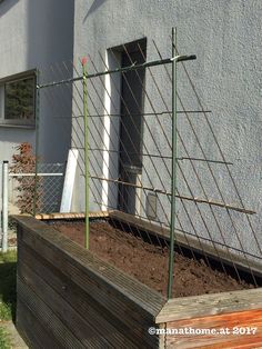 a garden bed in front of a house with a fence around it and a door