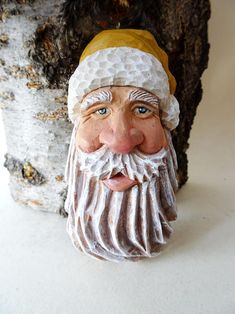 a close up of a figurine of a man with a beard next to a tree