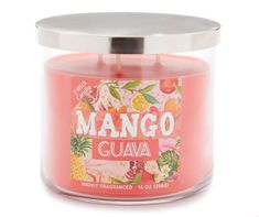 a pink candle with an orange and pineapple label on the lid that says mango guava