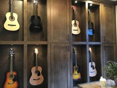 several guitars are lined up on shelves in a room