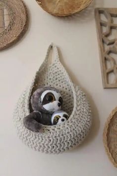 two stuffed animals in a crocheted hanging basket