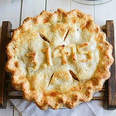 an apple pie sitting on top of a wooden table