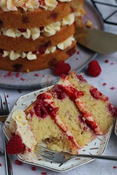 a slice of cake on a plate with raspberries and whipped cream toppings