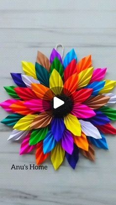 an origami sunflower made out of colored paper on a white background with the words annu's home written below it