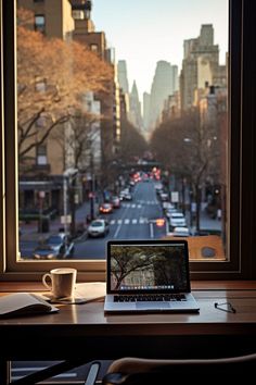 an open laptop computer sitting on top of a wooden desk next to a cup of coffee