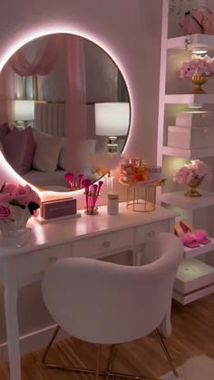 a white desk topped with a mirror next to a table filled with flowers and candles