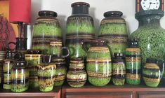 there are many vases and jars on the shelf