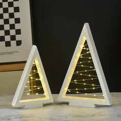 two white wooden christmas trees with lights on them