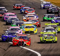 a group of cars driving down a race track with the number 24 on each car