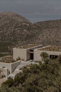 an exterior view of a house with stairs leading up to it and mountains in the background