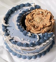 there is a blue and white cake with gold decorations on the top that looks like waves