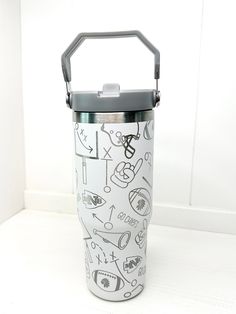 a white and black cup with some drawings on it