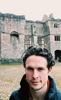 a man standing in front of an old castle