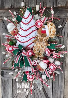 a christmas wreath with candy canes, cookies and candies on the front door