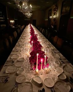 a long table is set with candles and plates in the shape of a heart for valentine's day