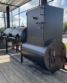 an outdoor wood fired stove sitting on top of a wooden deck