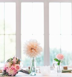 the table is set with flowers and vases