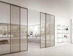 an empty white room with glass walls and shelves