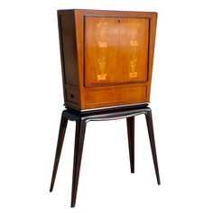 an old fashioned wooden cabinet sitting on top of a black stand next to a white wall