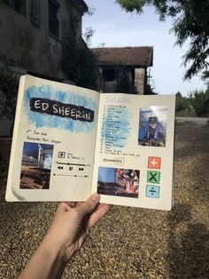 someone is holding up an open book with pictures on it in front of a building