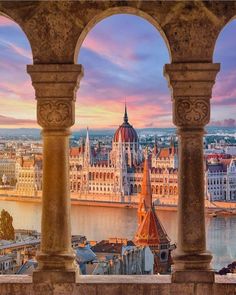 the city is surrounded by tall buildings and pillars with arches on each side, looking out over the water