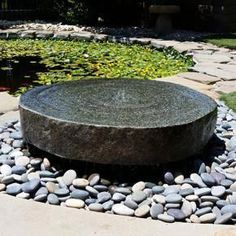 a rock fountain in the middle of a garden