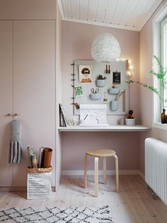 a room with pink walls and wooden flooring, including a small table in front of a radiator