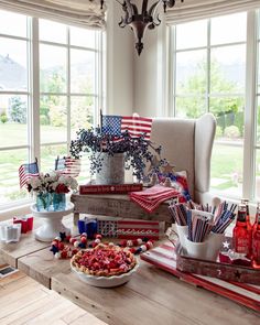 an american flag themed party with patriotic decorations and desserts on a table in front of large windows