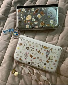 two laptops sitting on top of a bed covered in buttons and magnets,