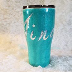 a turquoise colored tumbler with the word acro painted on it's side