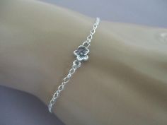 This dainty bracelet has a 5mm cherry blossom link in the center of sterling silver figure eight chain. The clasp is a sterling silver spring ring that can hook into any loop of the chain, making the bracelet adjustable up to 8". This bracelet is dainty and can break when tugged. Delicate Silver Chain Bracelet As Gift, Dainty Adjustable Sterling Silver Bracelet Nickel Free, Adjustable Sterling Silver Flower Bracelet, Dainty Silver Flower Bracelets, Delicate Silver Sterling Silver Bracelet As Gift, Spring Silver Bracelet Jewelry, Delicate Silver Bracelets With Flower Charm, Silver Flower Chain Bracelet Gift, Silver Flower Chain Bracelet For Gift