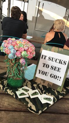 there is a sign that says it sucks to see you go and flowers in a vase