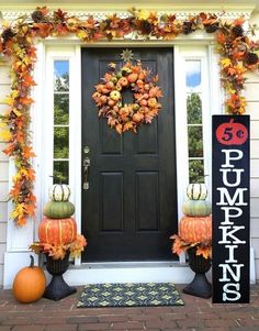 a front door decorated for fall with pumpkins and gourds