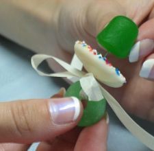 a woman's hands holding a green and white manicure