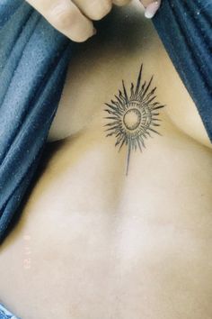 a woman with a sun tattoo on her back and shoulder, showing the upper part of her body