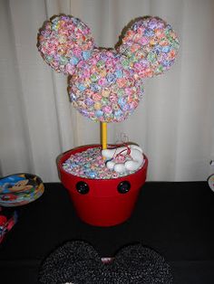 a mickey mouse topiary in a bucket filled with candy and marshmallows