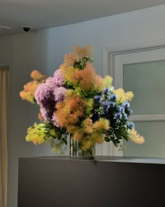 a vase filled with lots of different colored flowers