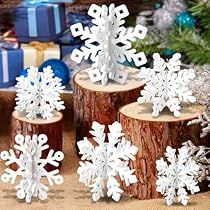 snowflakes are sitting on logs in front of presents