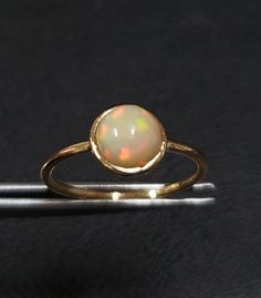 1. ethiopian opal 14k gold ring 2. made to order  3. gemstone - ethiopian opal 4. jewelry type - gold ring 5. total weight - 1.300 gram approx 6. opal weight - 1.03 cartas 7. gold weight - 1.093 gram approx 8. opal size - 7 mm 9. gold purity - 14k 10. handmade items 11. band size - 1.50 mm 12. high polished 13. aaa quality ring  14. stackable ring 15. 1 quantity available 16. ready to dispatch in 1 -2 days. 17. rare size / rare fire Gold Ethiopian Opal Ring Hallmarked, Gold Round Cut Opal Ring, Yellow Gold Cabochon Opal Ring, Minimalist Round Cabochon Opal Ring, Gold Opal Ring With Bezel Setting, 14k Yellow Gold Opal Ring, 14k Gold Opal Ring With Round Band, Gold Ethiopian Opal Cabochon Ring, Yellow Gold Ring With Ethiopian Opal And Birthstone