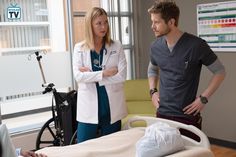 a man and woman standing around a hospital bed