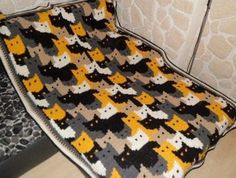 a crocheted blanket with cats on it