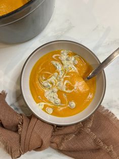 a white bowl filled with soup next to a metal pot